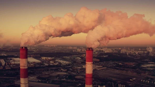 Luchtfoto van twee vervuilende rookkanalen in de industriële wijk van de stad in de ochtend — Stockfoto