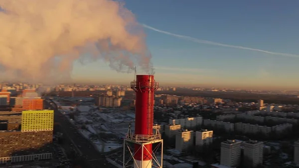 Tiro aéreo de uma pilha de fumaça vermelha industrial poluente do ar na área urbana — Fotografia de Stock