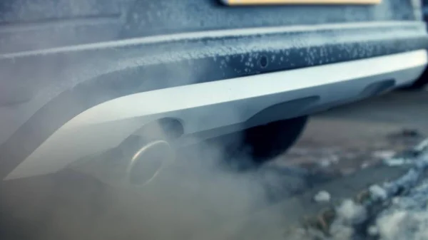 Nahaufnahme von Rauch aus dem Auspuff eines vereisten Autos. Kaltes Wetter im Winter — Stockfoto
