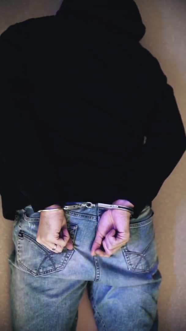 床上の手錠に警察のストローブライト付きの犯罪者。逮捕関連の銃撃 — ストック動画