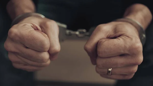 Кулаки человека в наручниках — стоковое фото