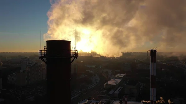 Fumaça de pilhas industriais no fundo do pôr do sol na cidade, vista aérea — Fotografia de Stock