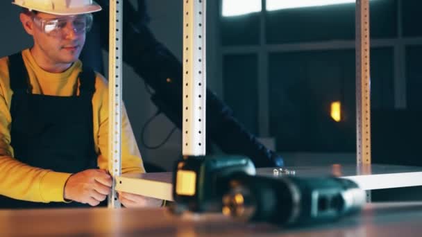 Male worker wearing hard hat assembles the industrial equipment — Stock Video