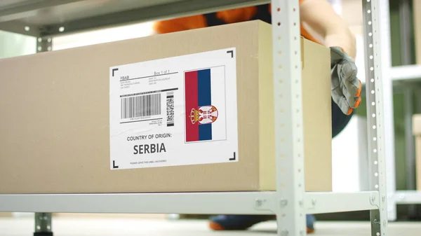 Pudełko tekturowe z produktami pochodzącymi z Serbii i pracownikami magazynu — Zdjęcie stockowe