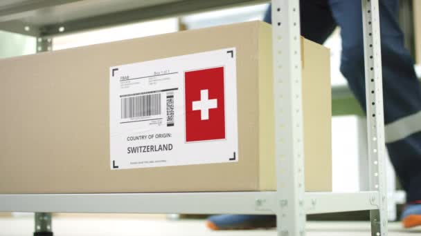 Kartong med produkter från Schweiz och lageranställd — Stockvideo