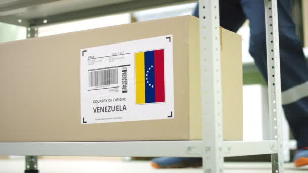 Employé de stockage enlève un carton avec des marchandises du Venezuela — Video