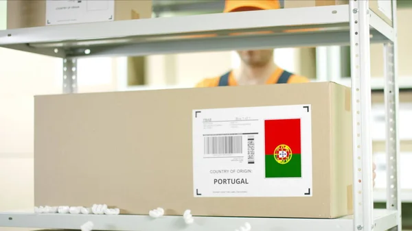 Pracovník skladu dává karton se zbožím z Portugalska — Stock fotografie