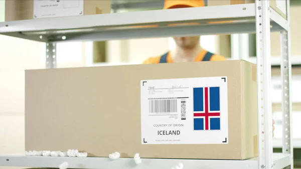 Pracownik magazynu umieszcza karton z towarami z Islandii — Zdjęcie stockowe