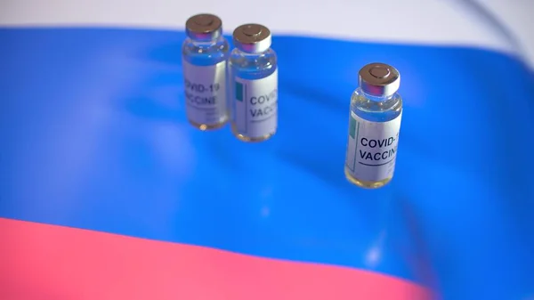 Injekční lahvičky s vakcínou COVID-19 a vlajkou Ruska — Stock fotografie