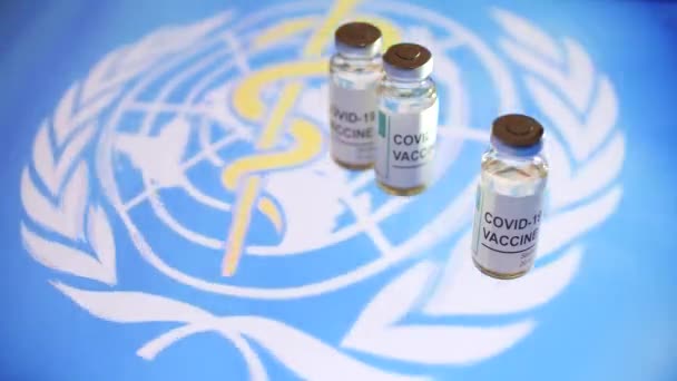 Flaconcini con vaccino COVID-19 e bandiera dell'Organizzazione Mondiale della Sanità — Video Stock