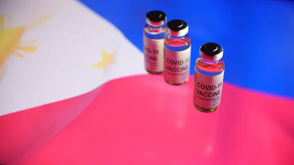 Tre flaconcini con vaccino COVID-19 e bandiera delle Filippine — Foto Stock