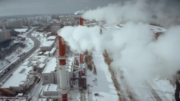 Luchtfoto van een schoorsteen van een elektriciteitscentrale in een stedelijke woonwijk in de winter — Stockvideo