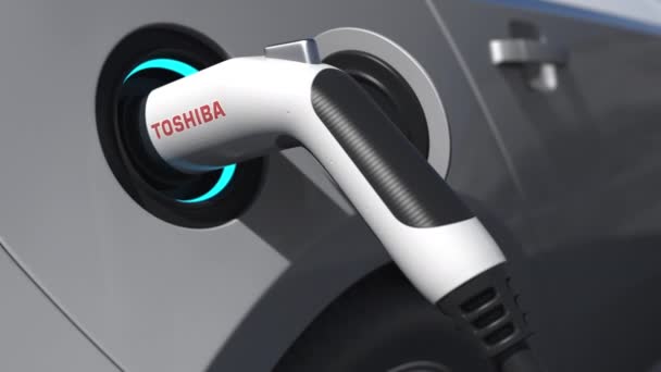 TOSHIBA-logotypen på elbilsproppen. Redaktionell konceptuell 3D-animation — Stockvideo