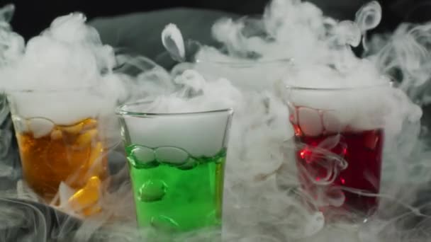 Close-up slow motion shot of colourful cocktails with smoking dry ice — Stok Video