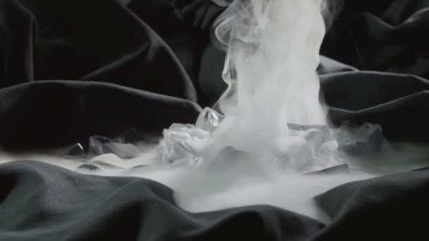 Hielo seco brumoso o dióxido de carbono congelado en tiro a cámara lenta textil negro — Vídeo de stock