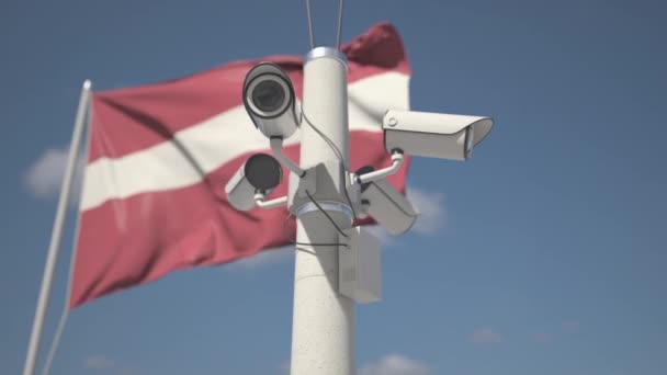 Mávejte vlajkou Lotyšska a bezpečnostními kamerami na sloupu. 3D animace smyčky — Stock video