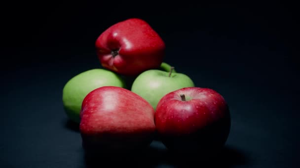 Красные и зеленые яблоки на темном фоне, петля быстро меняющихся видов — стоковое видео