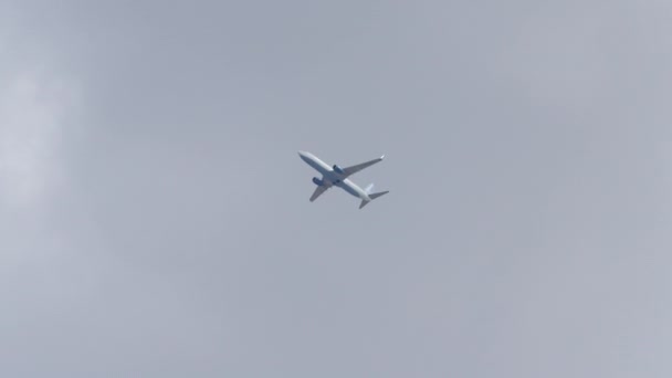 Avion commercial volant sur fond de ciel nuageux, téléobjectif tourné sur rouge — Video