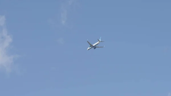 Vliegend commercieel vliegtuig op bewolkte lucht achtergrond, telelens geschoten — Stockfoto