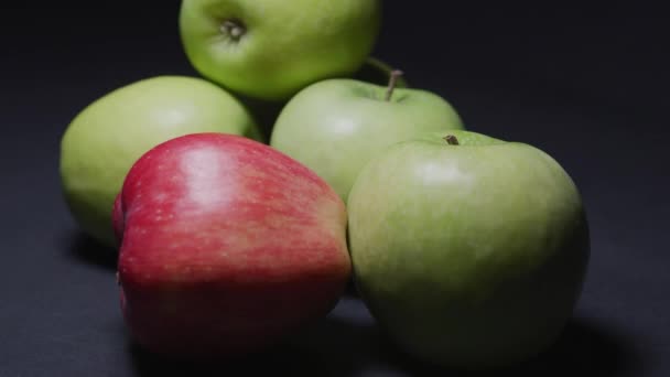 Manzanas verdes y rojas sobre fondo negro, tiro en bucle — Vídeos de Stock