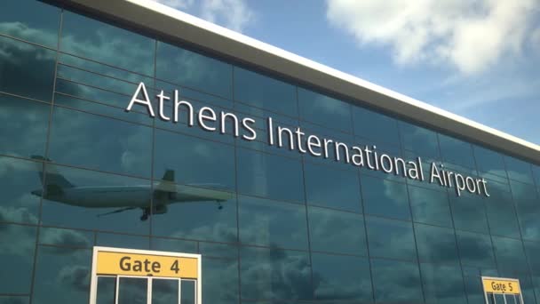 Avión comercial despegue reflejándose en las ventanas con texto del Aeropuerto Internacional de Atenas — Vídeos de Stock