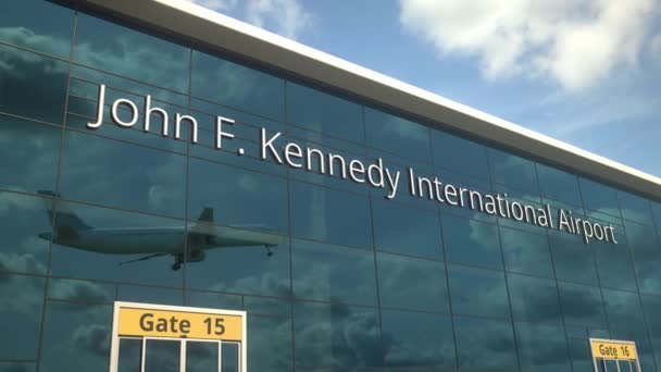 Taking off airplane reflecting in the modern windows with John F. Kennedy International Airport text — Stock Video