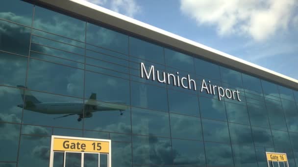 Startendes Flugzeug spiegelt sich in den modernen Fenstern mit dem Text vom Flughafen München — Stockvideo