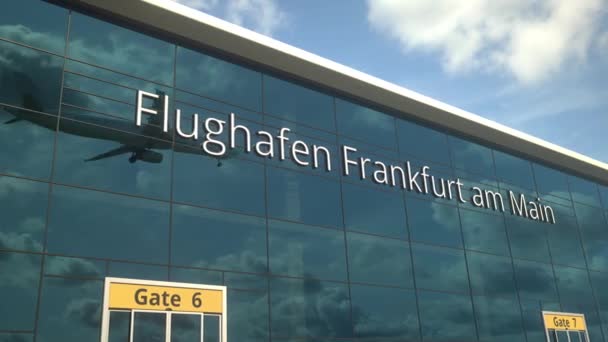 Pesawat mendarat mencerminkan jendela modern dengan teks Flughafen Frankfurt am Main atau Frankfurt am Main Airport — Stok Video