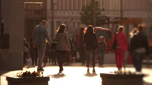 Tele shot of blurred crowd walking along the street at sunset — Stock Photo, Image