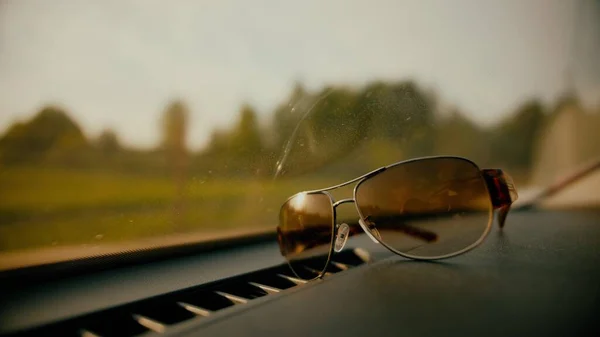 Коричневые очки в припаркованной машине в солнечный день — стоковое фото