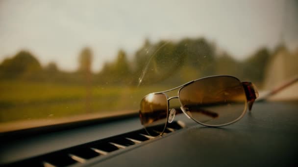 Gafas de sol marrones en un coche estacionado en un día soleado — Vídeo de stock