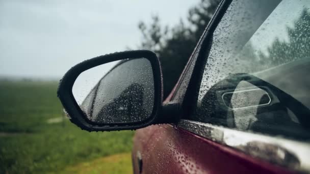 Капли дождя на зеркало заднего вида автомобиля в дождливый день — стоковое видео