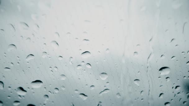 Gotas de lluvia en el parabrisas calentado eléctricamente de un coche en un día lluvioso — Vídeo de stock