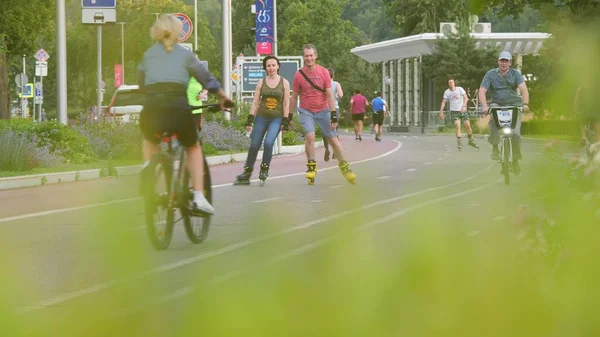 МОСКОВ, РОСІЯ - 5 - го липня 2021 р. Телефон з повільним рухом знімає людей, які їздять на велосипедах, катаються на ковзанах і бігають у парку Лужники. — стокове фото