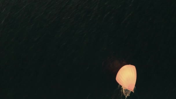 Luftaufnahme eines unbekannten Segelbootes mit orangefarbenem Segel auf dem Meer — Stockvideo