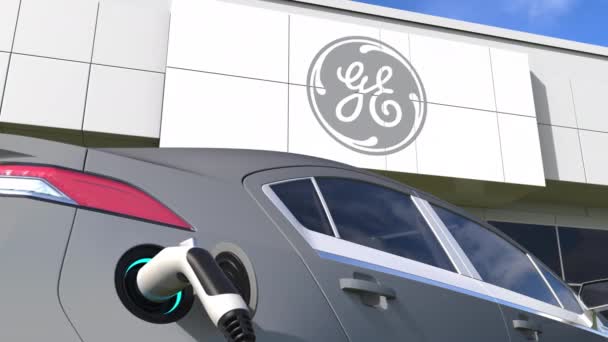 Заряджаючи електромобіль і логотип GENERAL ELECTRIC. Редакційна концептуальна 3D анімація — стокове відео