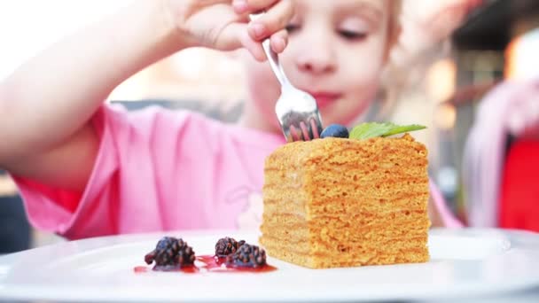 Mutlu küçük kız çatalla ballı kek yiyor. — Stok video