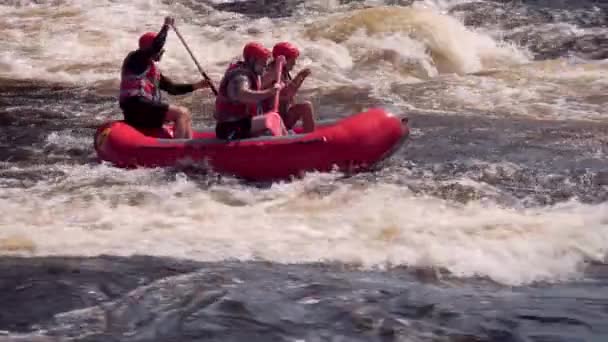 VUOKSI, Ryssland - 11 juli 2021. Människor på röd uppblåsbar flotte på forsar av vitvatten Vuoksi floden, tele skott — Stockvideo