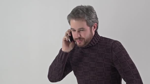 Man in sweater talking on a mobile phone — Stock Video