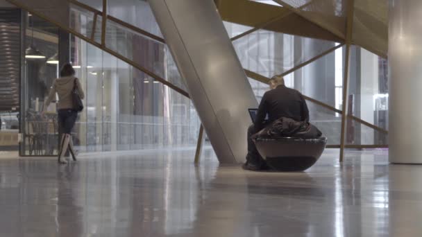 Şehir merkezinde dizüstü bilgisayar ile adam oturur — Stok video