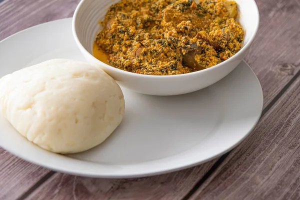 Egusi-Kavun Çorbası ile servis edilen bir kase Pounded Yam.