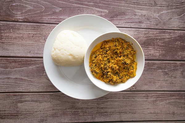 Egusi-Kavun Çorbası ile servis edilen bir kase Pounded Yam.