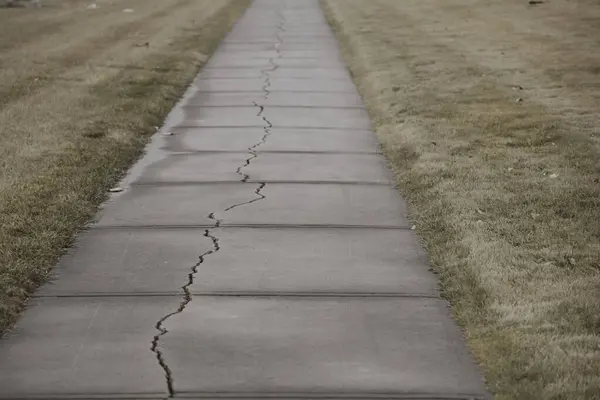 Concrete footpath pavement cracked split down the middle — Photo