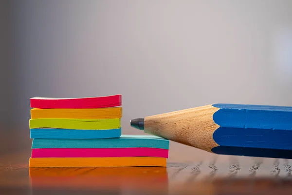 Groot potlood met een verzameling kleurrijke plakkerige notities aan het werk — Stockfoto