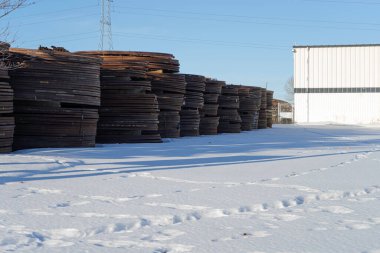 Üretim için dışarıda depolanmış metal bobinler.