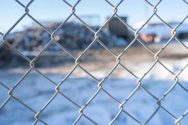 Clôture à maillons de chaîne avec décharge de recyclage des déchets derrière elle — Photo