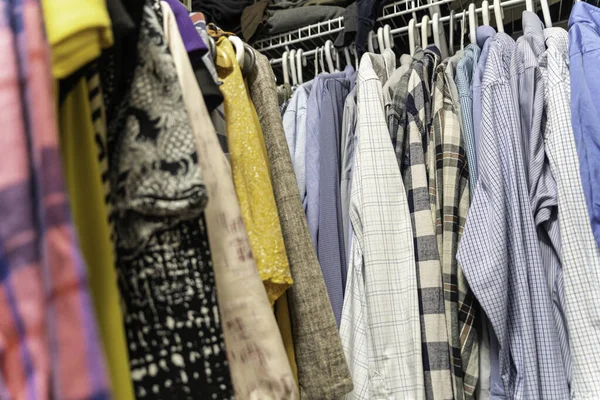 Мужская и женская одежда расставлены и висят в шкафу — стоковое фото