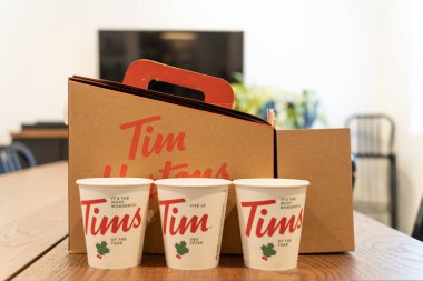3 Şubat 2021 - Calgary, Alberta Canada - Tim Hortons çörek kutusu ve sehpanın üzerinde kahve