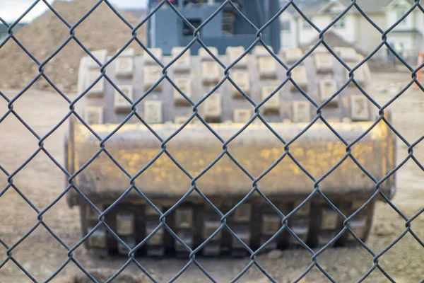 Matériel de construction derrière une clôture en treillis métallique sur le site — Photo