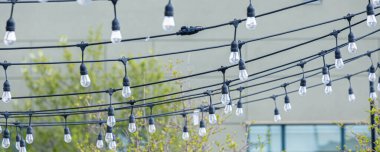 Dışarıdaki restoran avlusuna asılmış elektrik ampulleri dizisi.